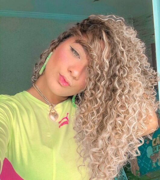 cabelo cacheado com luzes loiro platinado