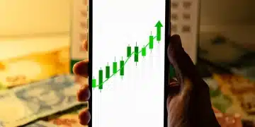 Mão segurando smartphone com gráfico financeiro de Tesouro Direto, notas de real e calendário 2026 ao fundo.