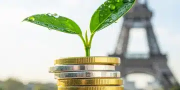 Jeune pousse verte émergeant d'une pile de pièces en euros, avec la Tour Eiffel floue en arrière-plan, symbolisant les placements financiers verts en France.