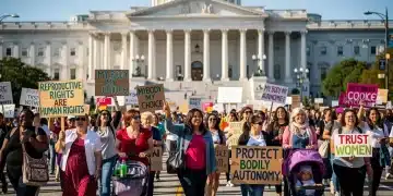 Women's march for reproductive rights outside a legislative building, advocating for healthcare access and bodily autonomy.